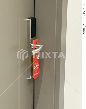 Do not disturb door hanger on hotel room door indicating guest privacy background Do not disturb door hanger on hotel room door indicating guest privacy background 135451404