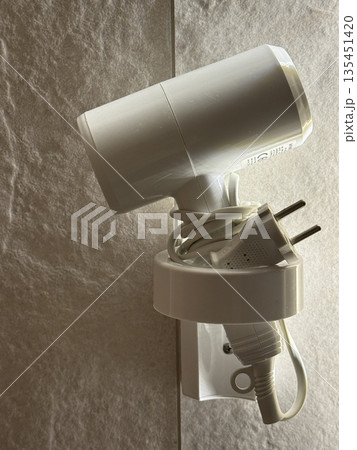LED spotlight on textured wall for indoor use with cable wrapped around, ideal for background LED spotlight on textured wall for indoor use with cable wrapped around, ideal for background 135451420