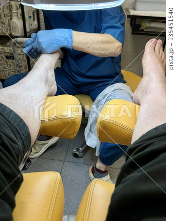 Hardware medical pedicure using a drill and nail files. A patient has a pedicure at a podiatrist. A dangerous fungal lesion of human toenails. Onychomycosis, treatment of nail fungus. 135451540