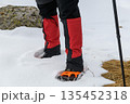 Hiker legs with crampons in snow 135452318