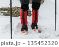 Hiker legs with crampons in snow 135452320