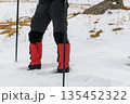 Hiker legs with crampons in snow 135452322