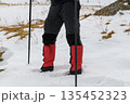 Hiker legs with crampons in snow 135452323
