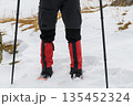 Hiker legs with crampons in snow 135452324