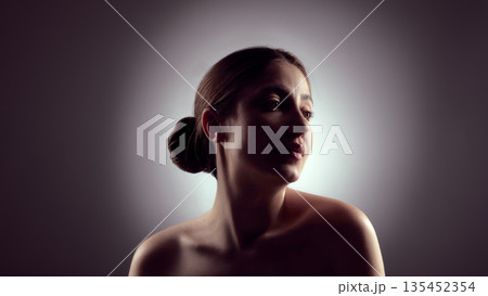 Low key female portrait with upward gaze and soft highlights. Low key female portrait with upward gaze and soft highlights. 135452354