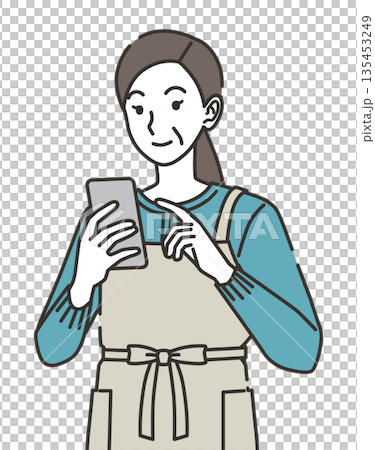 スマホを見るエプロン姿の主婦 135453249