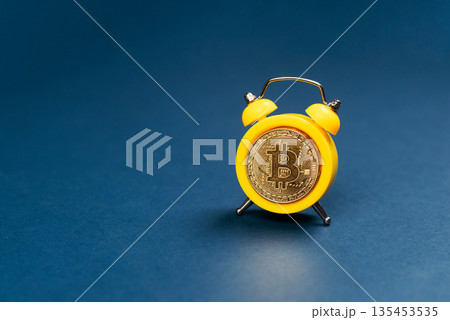 Concept deadline to invest in cryptocurrency showing alarm clock with a bitcoin as the clock face on blue background. Time to invest in bitcoin idea. 135453535