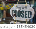 Wooden Closed Sign Hanging on Store Door Entrance 135454020