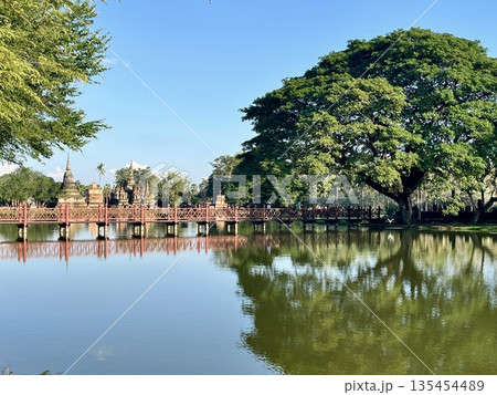 スコータイ歴史公園のワット トラパングーンと水面に映る赤い橋 135454489