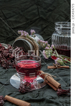 Roselle tea (Jamaica sorrel, Rozelle or hibiscus sabdariffa ) with dry roselle and brown cane sugar cube. 135454773