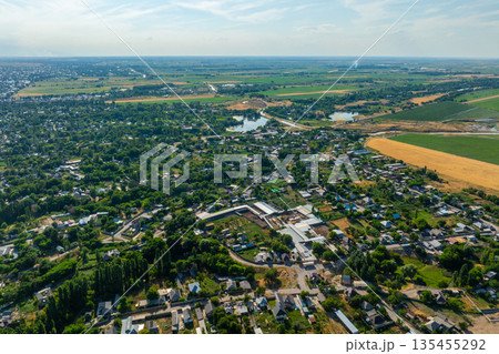 Aerial view of peaceful rural flat Kyrgyzstan landscape with fields and water 135455292