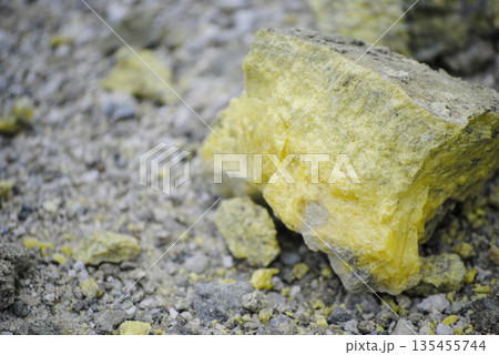 Macro shot of vibrant yellow sulfur crystals on a fumarole field. Natural mineral deposits on the slopes of Kuril Islands. 135455744