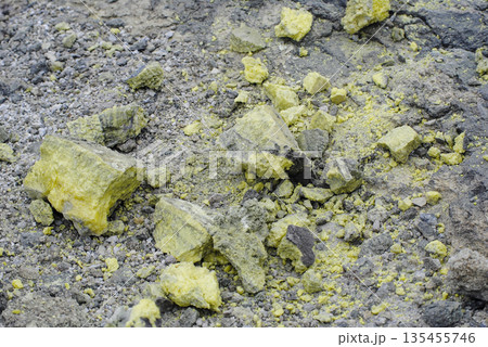 Macro shot of vibrant yellow sulfur crystals on a fumarole field. Natural mineral deposits on the slopes of Kuril Islands. Macro shot of vibrant yellow sulfur crystals on a fumarole field. Natural mineral deposits on the slopes of Kuril Islands. 135455746
