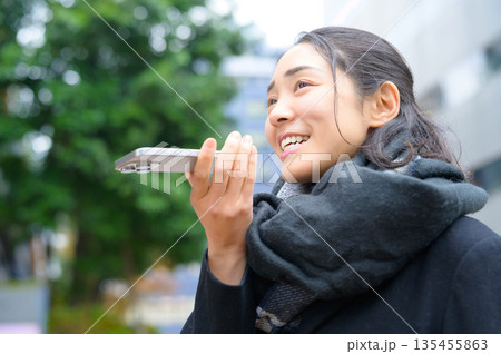 スマホを使用するマフラーをした女性 スマホを使用するマフラーをした女性 135455863
