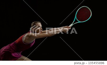 Female tennis player lunging for shot with dynamic motion 135455896