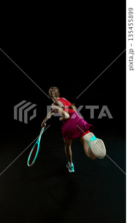 Female tennis athlete dynamic jump shot in studio scene. 135455899