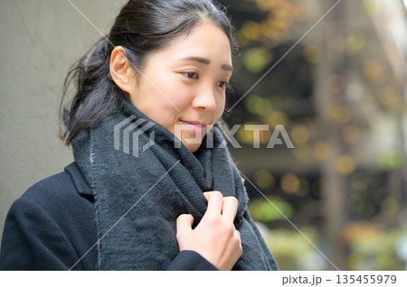冬の屋外を歩くマフラーをした女性 135455979