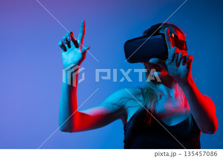 Virtual reality interaction with woman using hand gestures, immersive digital interface and metaverse technology experience 135457086