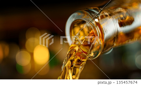 Pouring Whiskey from Bottle . Stream of Golden Liquid Flows on a Pub Pouring Whiskey from Bottle . Stream of Golden Liquid Flows on a Pub 135457674