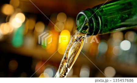 Pouring Beer from Green Bottle . Stream of Golden Carbonated Liquid Flows in Slow Motion on a Pub 135457686