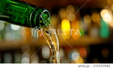 Pouring Beer from Green Bottle . Stream of Golden Carbonated Liquid Flows in Slow Motion on a Pub 135457688