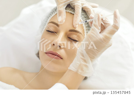 Cosmetologist makes rejuvenating anti wrinkle injections on face of beautiful woman. Cosmetologist makes rejuvenating anti wrinkle injections on face of beautiful woman. 135457845