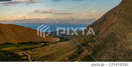Winding road through serene mountainous landscape at sunset Winding road through serene mountainous landscape at sunset 135458592
