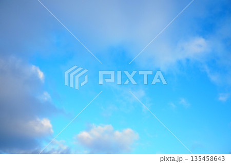 A vast expanse of bright blue sky complements billowy white clouds, creating a tranquil atmosphere. This serene backdrop enhances moments of peace and inspires dreams under the endless sky 135458643
