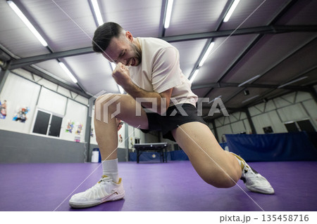 Male athlete celebrating victory in indoor sports court 135458716