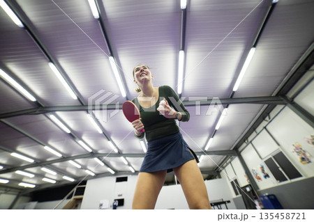 Young woman serving table tennis ball playing indoor sport 135458721