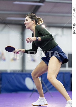 Young woman playing competitive table tennis indoors Young woman playing competitive table tennis indoors 135458736