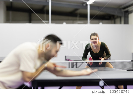 Woman smiling playing table tennis match Woman smiling playing table tennis match 135458743