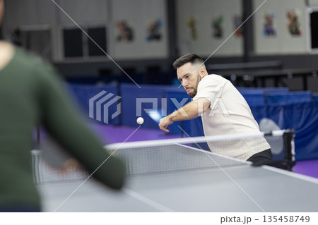 Man playing table tennis hitting ball during game Man playing table tennis hitting ball during game 135458749