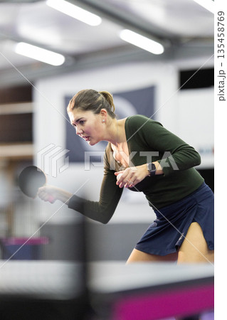Young woman playing table tennis game indoors Young woman playing table tennis game indoors 135458769