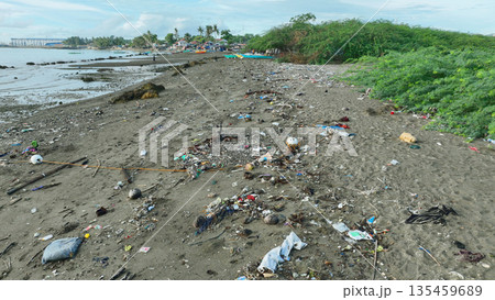 Shoreline trash full of plastic waste rubbish and overwhelming abundance garbage. Environmental pollution and polluting the ocean. Marine debris in seashore like glass, metal can be dangerous for Shoreline trash full of plastic waste rubbish and overwhelming abundance garbage. Environmental pollution and polluting the ocean. Marine debris in seashore like glass, metal can be dangerous for 135459689