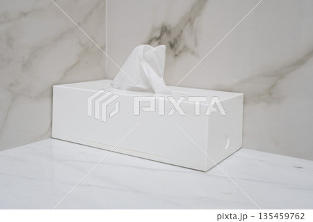 Minimal white tissue box with paper napkin on marble bathroom countertop in modern hotel interior 135459762