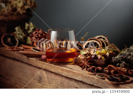 Herbal liquor and natural ingredients like herbs, roots, dried citrus slices, spices visible. 135459900