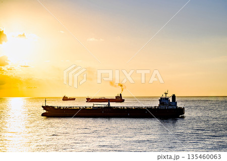 Cargo ships sailing at sunset, towards the port of Barcelona Cargo ships sailing at sunset, towards the port of Barcelona 135460063