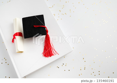 Graduation mortarboard and diploma representing academic success 135460191