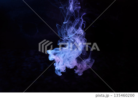 Colored smoke swirling on black background creating abstract fluid shapes Colored smoke swirling on black background creating abstract fluid shapes 135460200