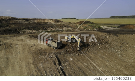 Excavator loading dump truck at construction site. Clip 135460238