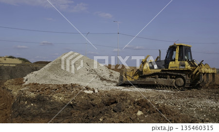 Bulldozer moving gravel on construction site under blue sky. Clip Bulldozer moving gravel on construction site under blue sky. Clip 135460315