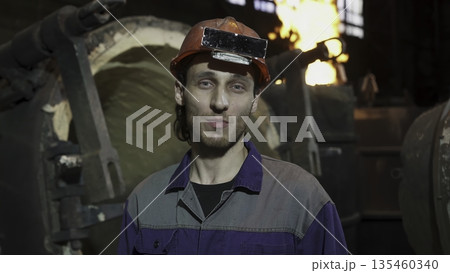 Industrial worker communicating near furnace in steel mill. Stock clip 135460340