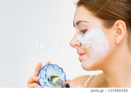 Girl black mask on half face apply white mud 135460388