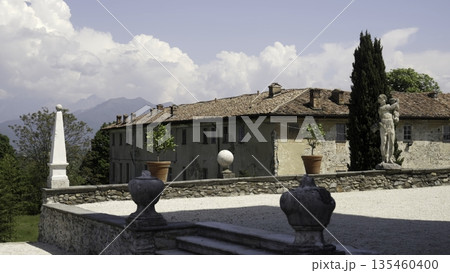 Elegant italian villa with statue and obelisk under cloudy sky. Action Elegant italian villa with statue and obelisk under cloudy sky. Action 135460400