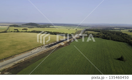 Highway construction progressing through agricultural landscape. Clip 135460450