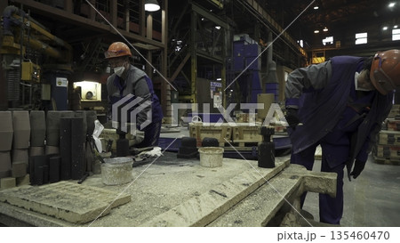 Foundry workers preparing molds for metal casting. Stock clip 135460470