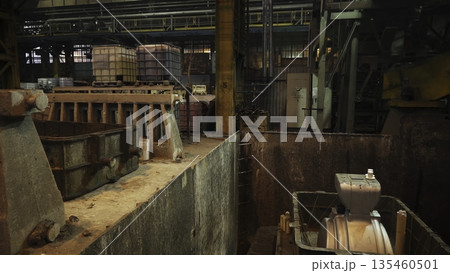 Industrial robotic arm pouring molten metal into mold in foundry. Stock clip 135460501