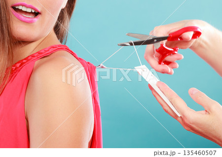 Woman cutting off removing label board price tag. 135460507