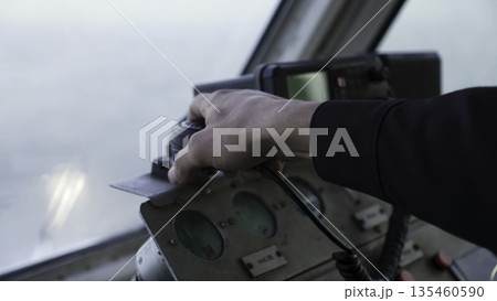 Captain using vhf radio and adjusting controls on ship's bridge. Clip Captain using vhf radio and adjusting controls on ship's bridge. Clip 135460590
